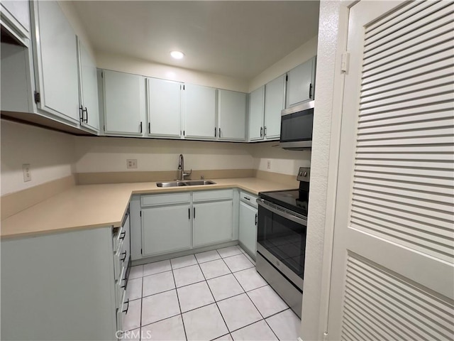 kitchen with stainless steel appliances, sink, light tile patterned floors, and gray cabinets