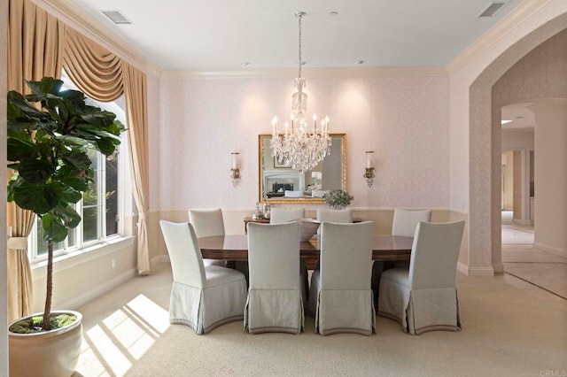 carpeted dining room featuring an inviting chandelier and crown molding