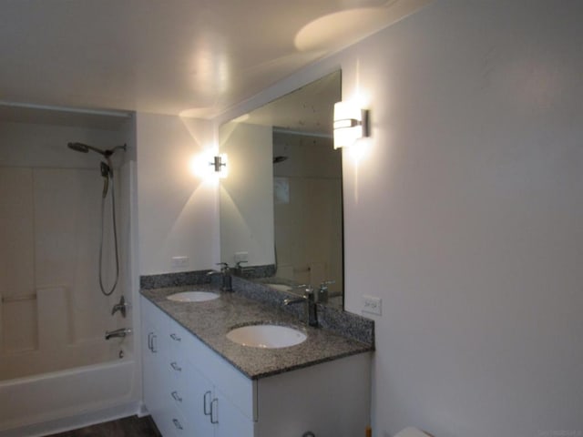 bathroom with tiled shower / bath and vanity