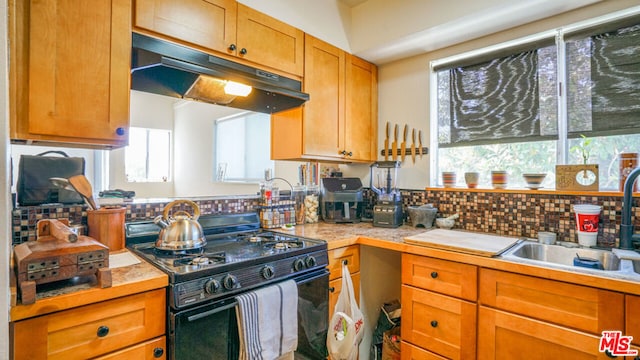 kitchen with gas stove, backsplash, and sink