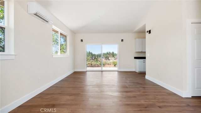 unfurnished living room with dark wood-type flooring and a wall mounted AC