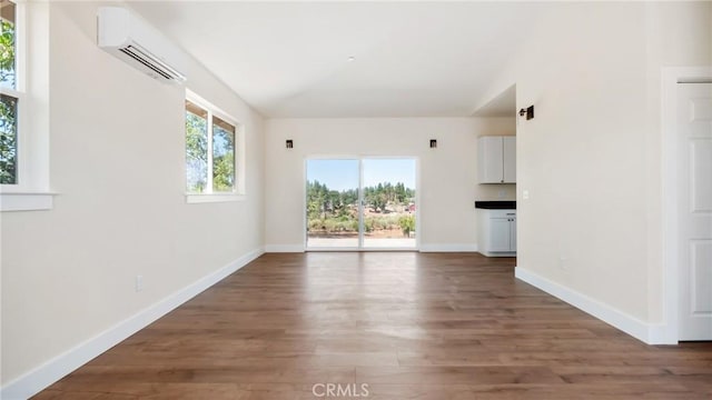 6241 Mountain View Dr, Paradise, CA 95969 - unfurnished living room with an AC wall unit, wood finished floors, baseboards, and lofted ceiling