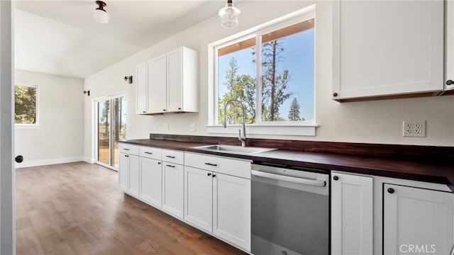 kitchen with white cabinetry, wooden counters, light hardwood / wood-style flooring, stainless steel dishwasher, and sink