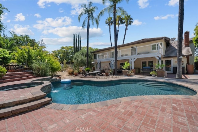 view of swimming pool with an in ground hot tub, pool water feature, and a patio