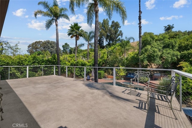 view of patio / terrace with a pool and a balcony