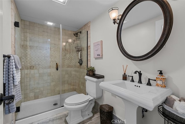 bathroom featuring toilet and an enclosed shower