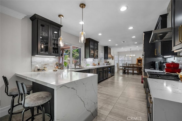 kitchen featuring decorative backsplash, hanging light fixtures, an inviting chandelier, range, and light stone counters