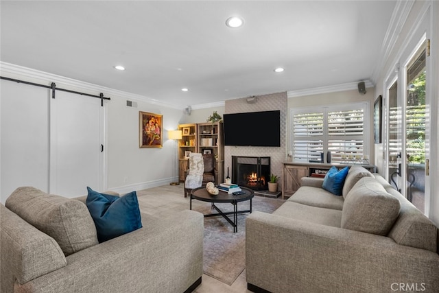 living room featuring ornamental molding, a barn door, light colored carpet, and a fireplace