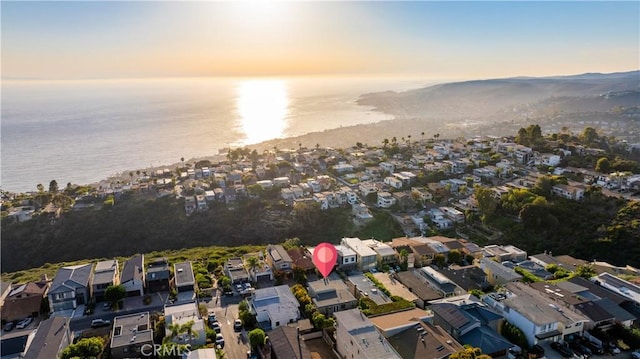 aerial view at dusk featuring a water view