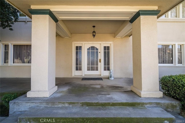 entrance to property featuring stucco siding, french doors, and a patio area