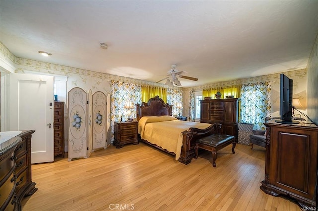 bedroom featuring wallpapered walls, light wood-style floors, and ceiling fan