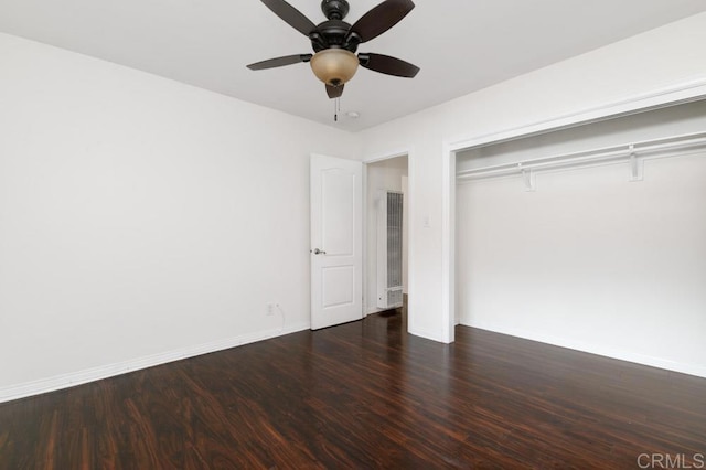 unfurnished bedroom featuring ceiling fan, dark hardwood / wood-style flooring, and a closet