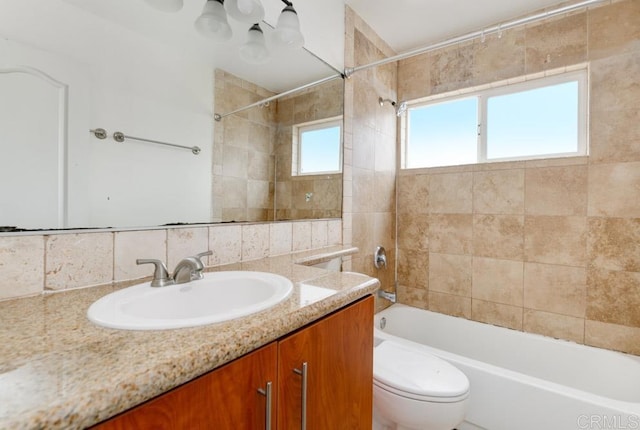 full bathroom featuring vanity, toilet, tiled shower / bath, and tasteful backsplash