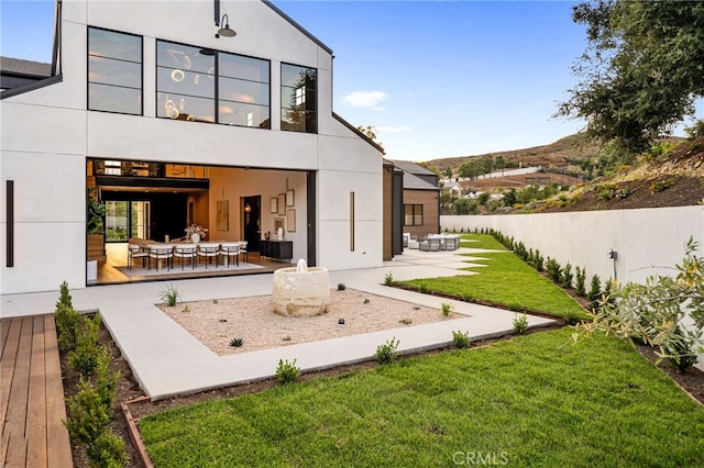 back of property with a yard, a patio, and an outdoor hangout area