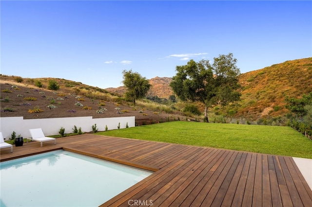 exterior space with a fenced in pool, a mountain view, and a yard