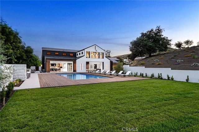 back of house with a patio, a fenced in pool, and a lawn