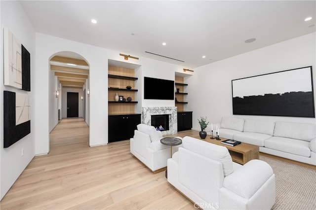 living room featuring beamed ceiling and light wood-type flooring