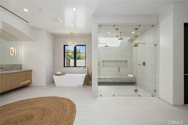 bathroom featuring vanity, separate shower and tub, tile walls, and a notable chandelier