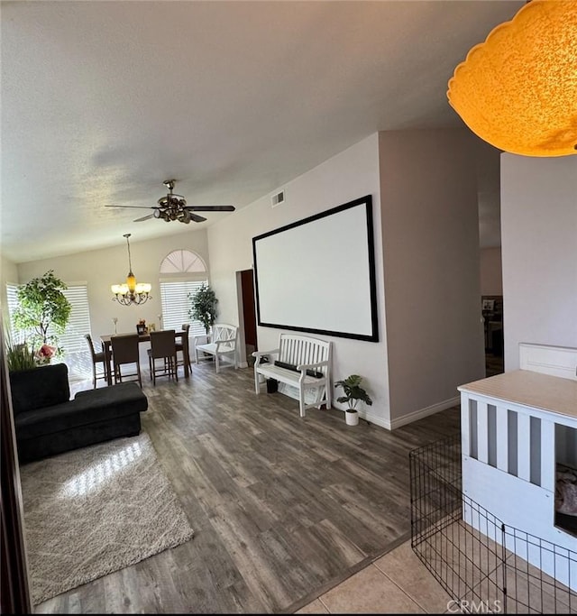 home theater room with a textured ceiling, ceiling fan with notable chandelier, and hardwood / wood-style flooring