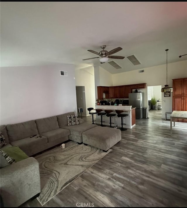 living room with high vaulted ceiling, ceiling fan, and dark wood-type flooring