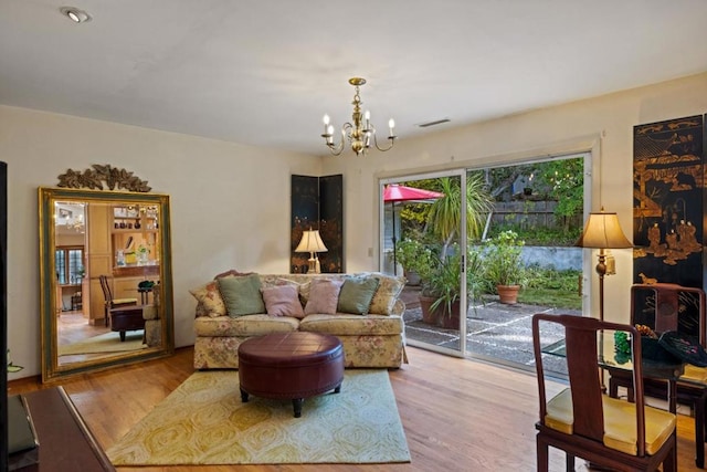 living room with light hardwood / wood-style floors and an inviting chandelier