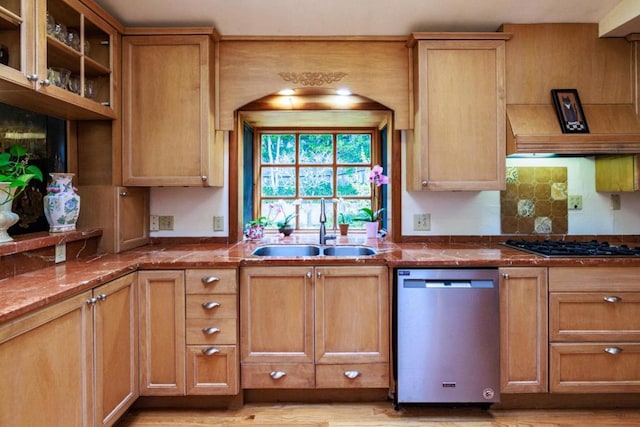 kitchen with stone counters, light wood-type flooring, stainless steel appliances, and sink