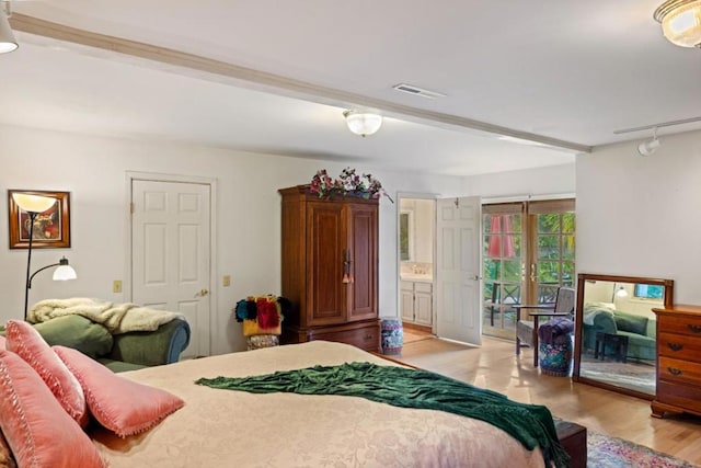 bedroom with french doors, rail lighting, ensuite bath, access to exterior, and light wood-type flooring