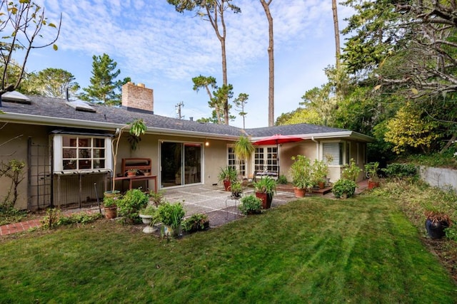 rear view of property with a lawn and a patio