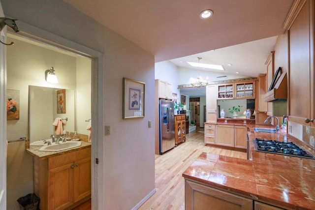 kitchen featuring a chandelier, sink, stainless steel appliances, and light hardwood / wood-style floors