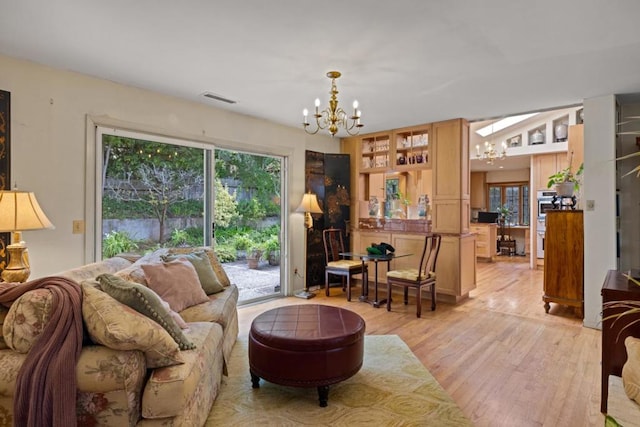 living room featuring a notable chandelier and light hardwood / wood-style floors