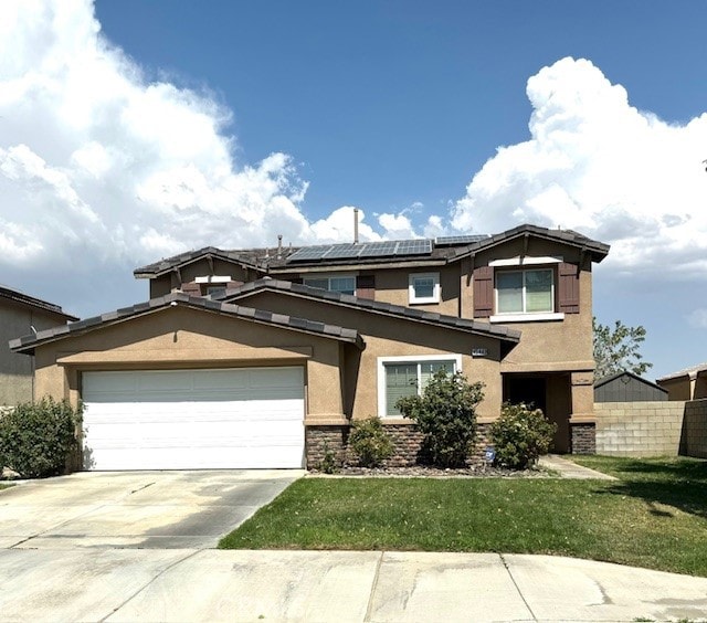 view of front of home with a garage, a front lawn, and solar panels