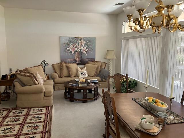 living room with carpet flooring and a notable chandelier