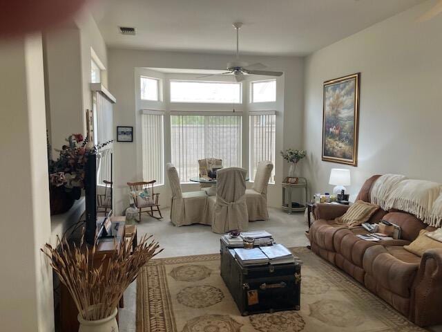 carpeted living room with ceiling fan