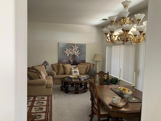 living room featuring carpet and a chandelier