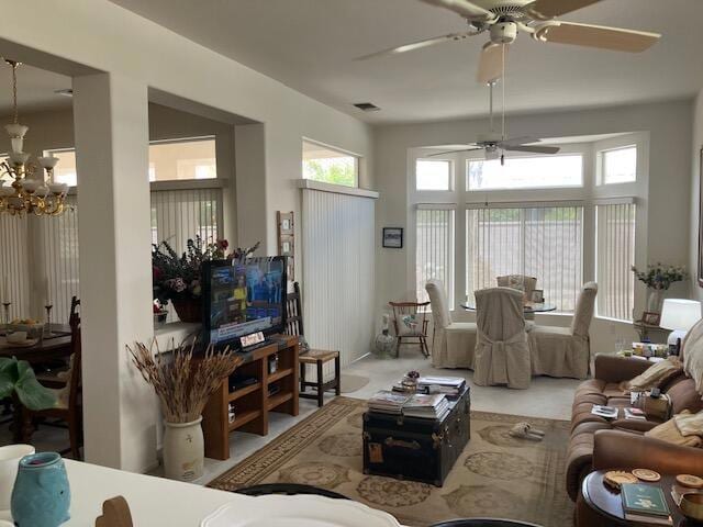 living room with ceiling fan with notable chandelier