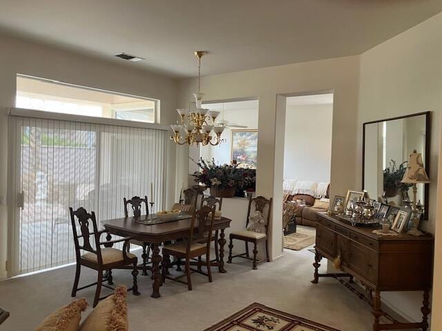 carpeted dining area with a notable chandelier