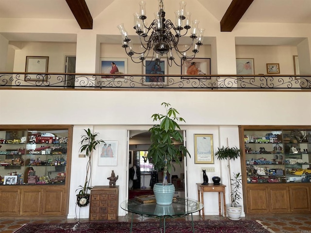 interior space featuring a notable chandelier, a towering ceiling, and beamed ceiling