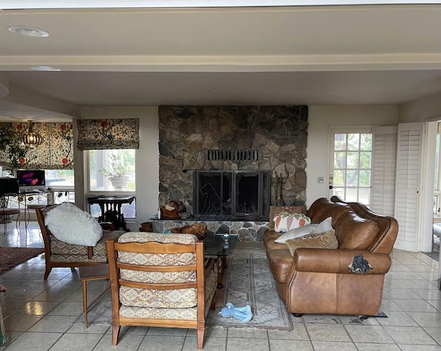 tiled living room with a stone fireplace