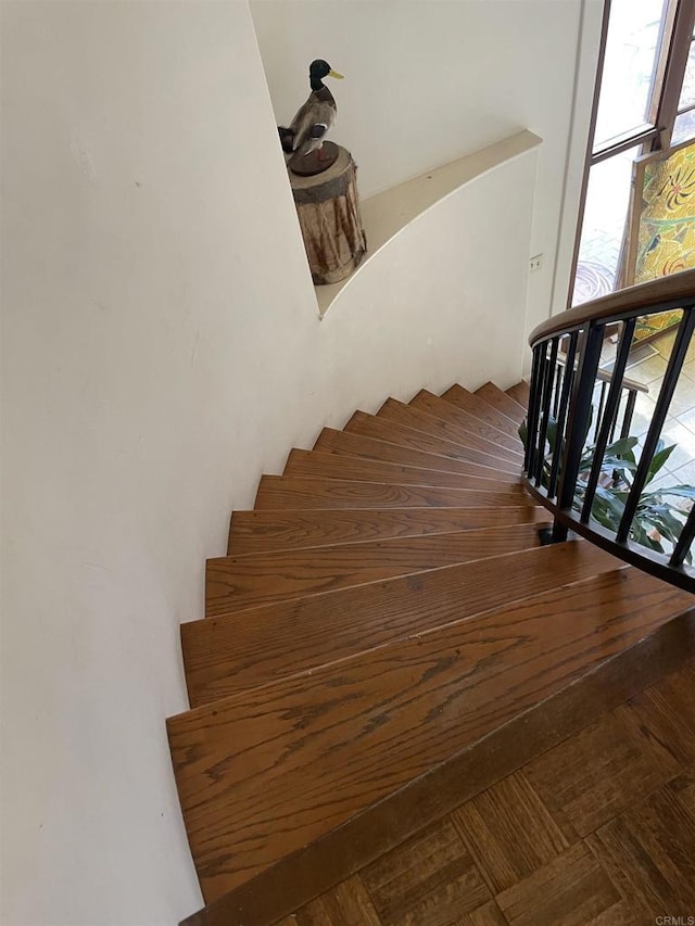 stairs featuring parquet flooring