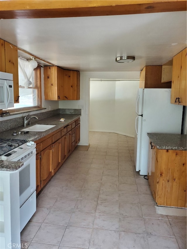 kitchen with sink, light tile patterned floors, and white appliances