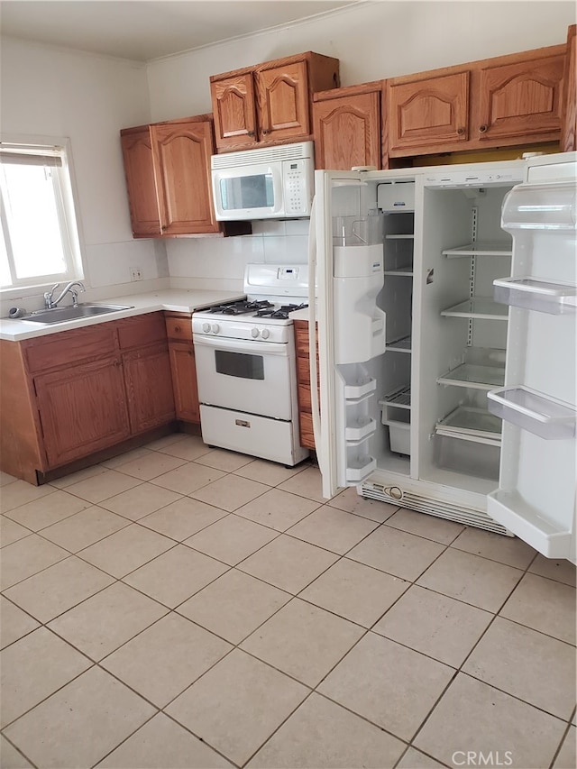 kitchen with light tile patterned flooring, sink, backsplash, and white appliances