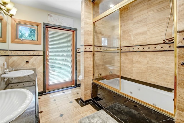 bathroom with tiled shower / bath, vanity, tile walls, and tile patterned floors