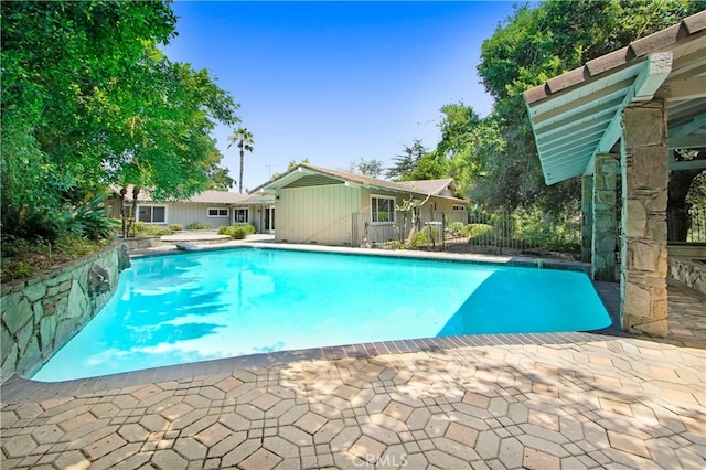 view of pool with a diving board and a patio area