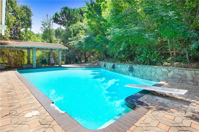 view of pool featuring a patio and a diving board