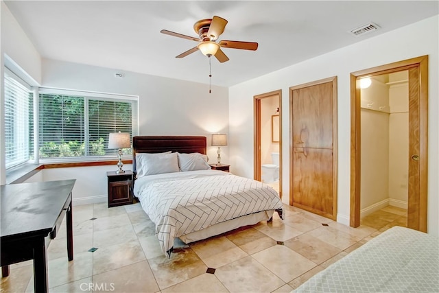 tiled bedroom featuring ceiling fan and connected bathroom