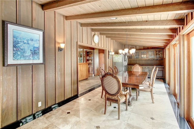 unfurnished dining area with an inviting chandelier, lofted ceiling with beams, wood walls, and wooden ceiling