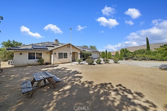 back of house featuring solar panels and a mountain view