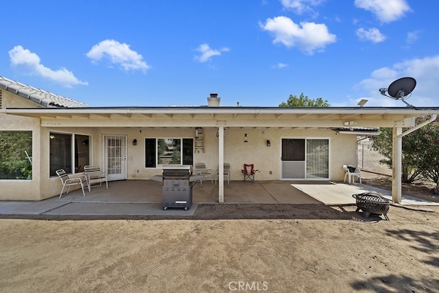 rear view of house featuring a patio area and an outdoor fire pit