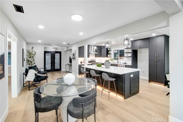 dining room featuring light hardwood / wood-style flooring, french doors, and sink