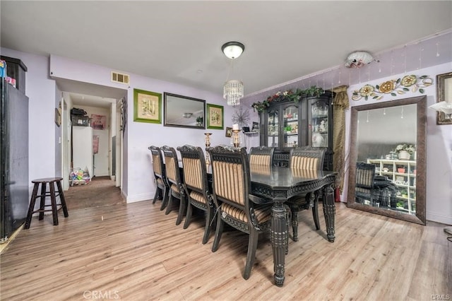 dining room featuring light hardwood / wood-style floors and a chandelier